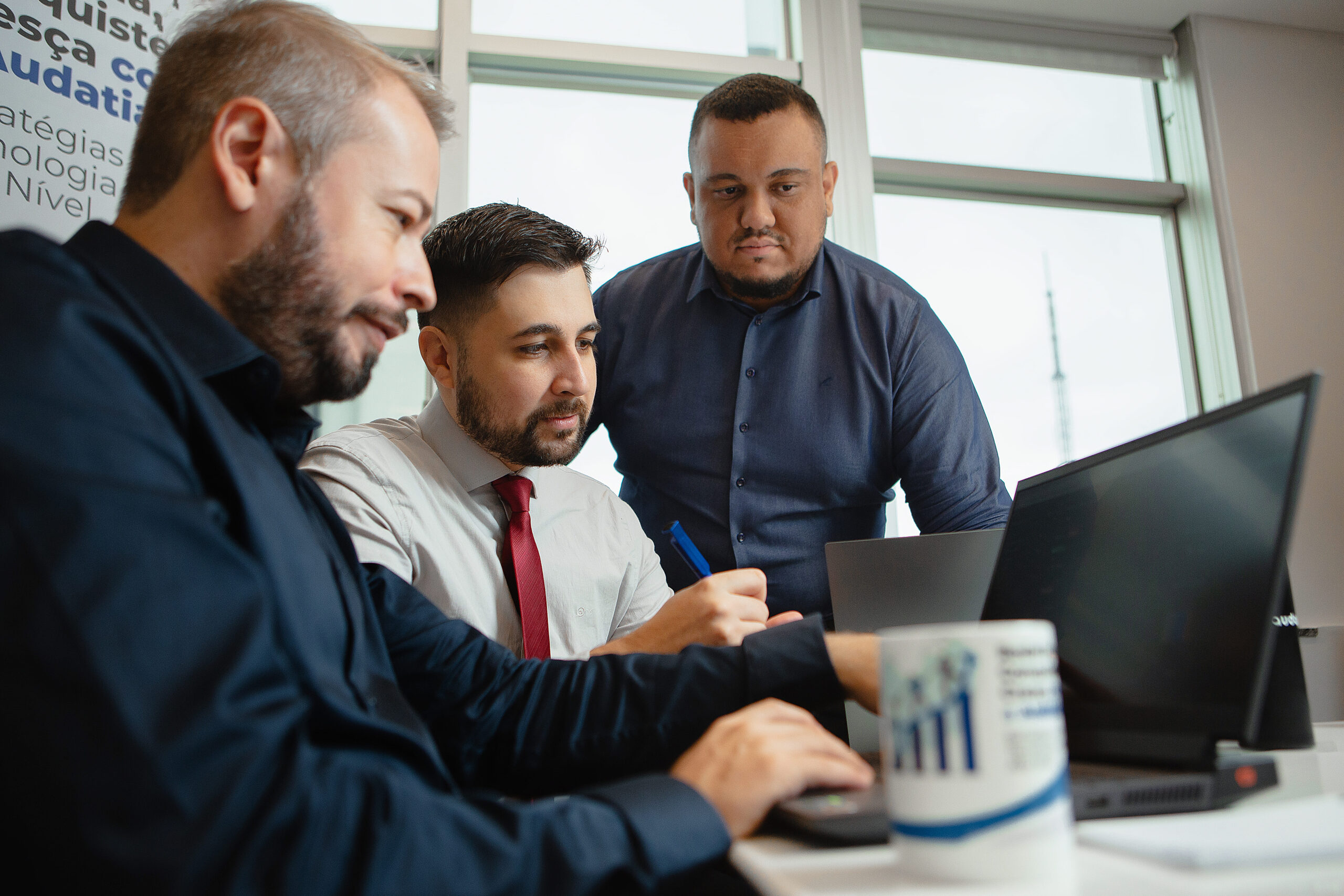 Consultores da Audatia trabalhando junto a um cliente na configuração da plataforma de gestão